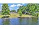 The home overlooks the lake from the shoreline and shows a backyard with mature landscaping at 118 Lake Sears Dr, Winter Haven, FL 33880