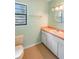 Bright bathroom with a toilet, single sink vanity, and a large window at 120 Bolender Rd, Auburndale, FL 33823
