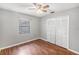 Bedroom with hardwood floors, neutral walls, ceiling fan and a double closet at 120 Bolender Rd, Auburndale, FL 33823