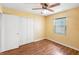 Bedroom with laminate floors, bright yellow walls, ceiling fan and a double closet at 120 Bolender Rd, Auburndale, FL 33823
