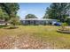 Charming single-story home featuring a metal roof, blue facade, and expansive front yard with garden at 120 Bolender Rd, Auburndale, FL 33823