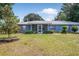 Charming single-story home boasts a metal roof, blue facade, and a spacious front yard at 120 Bolender Rd, Auburndale, FL 33823