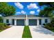 Modern duplex featuring dual garages, well-manicured lawns, and pristine landscaping at 1251 Dosseywood Ln, Lakeland, FL 33811