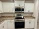 Updated kitchen with white cabinetry, stainless steel appliances, and ample countertop space at 1251 Dosseywood Ln, Lakeland, FL 33811