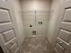 Compact laundry room with connections for washer and dryer with gray-tone tiled floor at 1251 Dosseywood Ln, Lakeland, FL 33811