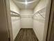 Spacious walk-in closet featuring sturdy wire shelving and stylish wood-look floors, offering ample storage at 1251 Dosseywood Ln, Lakeland, FL 33811
