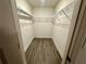 Open walk-in closet with wire shelving and wood-look flooring, providing generous storage space at 1251 Dosseywood Ln, Lakeland, FL 33811