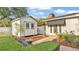 Backyard featuring white storage shed, brick pathway, and lush manicured hedges at 1421 Camphor Dr, Lakeland, FL 33803