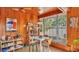Cozy dining area with wood-paneled walls and ceilings, featuring a square dining table and large windows at 1421 Camphor Dr, Lakeland, FL 33803