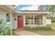 Inviting front entrance with red door, large windows, and lush landscaping at 1421 Camphor Dr, Lakeland, FL 33803