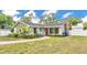 Charming single-story home featuring a red door, brick chimney, and mature landscaping at 1421 Camphor Dr, Lakeland, FL 33803
