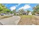 Well-manicured front yard with mature trees, brick walkway, and inviting red front door at 1421 Camphor Dr, Lakeland, FL 33803