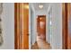 Hallway with wood-look laminate flooring with neutral colored walls and contrasting stained wood trim at 1421 Camphor Dr, Lakeland, FL 33803