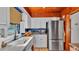 Bright kitchen features white cabinets, stainless steel refrigerator, and undermount sink under a window at 1421 Camphor Dr, Lakeland, FL 33803