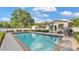Inviting in-ground pool featuring brick trim, lounge chairs, barbecue, and manicured landscaping in backyard at 1421 Camphor Dr, Lakeland, FL 33803