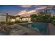 Evening shot of a in-ground pool featuring brick trim, lounge chairs and manicured landscaping at 1421 Camphor Dr, Lakeland, FL 33803