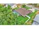Aerial shot of a beautiful home featuring a screened pool, lush lawn, and complemented by mature trees at 146 Woodside Dr, Lakeland, FL 33813