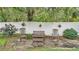 Relaxing backyard area with charming bench seating and tasteful plant decor against a white fence at 146 Woodside Dr, Lakeland, FL 33813