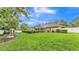 Spacious backyard featuring a screened-in pool area, lush lawn, and a play area at 146 Woodside Dr, Lakeland, FL 33813