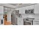 Bright kitchen featuring white cabinets, stainless steel appliances, and granite countertops at 146 Woodside Dr, Lakeland, FL 33813