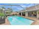 Enjoy the screened-in pool, surrounded by a brick patio and views of the landscaped backyard at 146 Woodside Dr, Lakeland, FL 33813