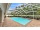Large screened-in pool offers a private oasis with brick patio and well-maintained landscaping at 146 Woodside Dr, Lakeland, FL 33813