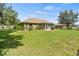 Expansive backyard with a well-maintained lawn, enclosed sunroom, and a secure black fence at 1519 Blue Sky Blvd, Haines City, FL 33844