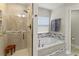 Bright bathroom showcasing a walk-in shower and a soaking tub with decorative mosaic tile at 1519 Blue Sky Blvd, Haines City, FL 33844
