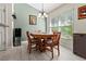 Cozy dining area featuring a classic wood table, large window with natural light and adjacent kitchen at 1519 Blue Sky Blvd, Haines City, FL 33844
