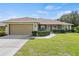 Attractive single-Gathering home featuring a neatly landscaped lawn, a 2-car garage, and a welcoming entrance at 1519 Blue Sky Blvd, Haines City, FL 33844