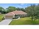 Charming single-story home featuring a well-manicured lawn, attached garage, and inviting front porch at 1519 Blue Sky Blvd, Haines City, FL 33844
