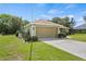 Spacious two car garage with an extended driveway and well maintained lawn with beautiful, bright landscaping at 1519 Blue Sky Blvd, Haines City, FL 33844