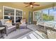 Cozy sunroom featuring large windows, tiled floors, seating and fan at 1519 Blue Sky Blvd, Haines City, FL 33844