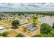 Aerial view of a vibrant community with a pool, tennis courts, and a scenic lake at 1565 Heather Hill Dr, Lakeland, FL 33810