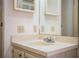 Bathroom vanity featuring a clean white countertop, integrated sink, chrome faucet, and framed mirror at 1565 Heather Hill Dr, Lakeland, FL 33810