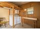 Bright laundry area featuring a washer, dryer, storage cabinet and wooden shelving at 1565 Heather Hill Dr, Lakeland, FL 33810