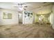 Spacious living room with plush carpeting and a ceiling fan, connected to a dining area at 1565 Heather Hill Dr, Lakeland, FL 33810