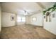 Bright, spacious living room with a ceiling fan, large windows with sheer curtains, and neutral carpet at 1565 Heather Hill Dr, Lakeland, FL 33810