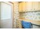 Small office with a built-in desk, cabinets, and floral wallpaper at 1565 Heather Hill Dr, Lakeland, FL 33810