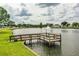 Scenic view of a community pond with a wooden pier and a tranquil fountain at 1565 Heather Hill Dr, Lakeland, FL 33810