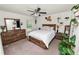 Cozy bedroom featuring a ceiling fan, dresser, nightstands, and decor at 1825 Wallace Manor Ln, Winter Haven, FL 33880
