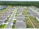 An aerial view of a residential neighborhood with well-maintained lawns and modern homes near a wooded area at 2039 Rosewood Cir, Lakeland, FL 33810