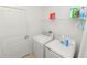 Practical laundry room with white washer and dryer, plus shelving for storage at 2039 Rosewood Cir, Lakeland, FL 33810