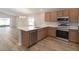 Open-concept kitchen with stainless steel appliances, wood cabinets, white countertops and view of the backyard at 2206 Oldham Ct, Haines City, FL 33844