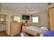 Cozy bedroom with a ceiling fan, TV, dresser, and glimpses of an ensuite bathroom at 224 Raymond Ave, Frostproof, FL 33843