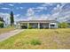 Charming single-story home with a covered carport and quaint front porch, set against a cloudy sky at 224 Raymond Ave, Frostproof, FL 33843