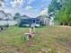 Spacious backyard with garden ornaments, a storage shed, mature tree coverage, and a white privacy fence at 236 E Seminole Ave, Lake Wales, FL 33853