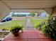 Front porch view with red tiling, greenery, and a glimpse of the neighborhood, offering a cozy and inviting entrance at 236 E Seminole Ave, Lake Wales, FL 33853