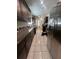 Galley-style kitchen featuring stainless steel appliances, granite countertops, dark wood cabinets, and tiled floor at 236 E Seminole Ave, Lake Wales, FL 33853