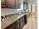 Kitchen showcases granite countertops, dark wood cabinets, a tiled backsplash, and ceramic tiled flooring at 236 E Seminole Ave, Lake Wales, FL 33853